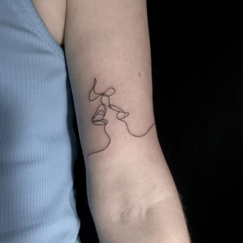 Fineline scribble tattoo op de bovenarm
