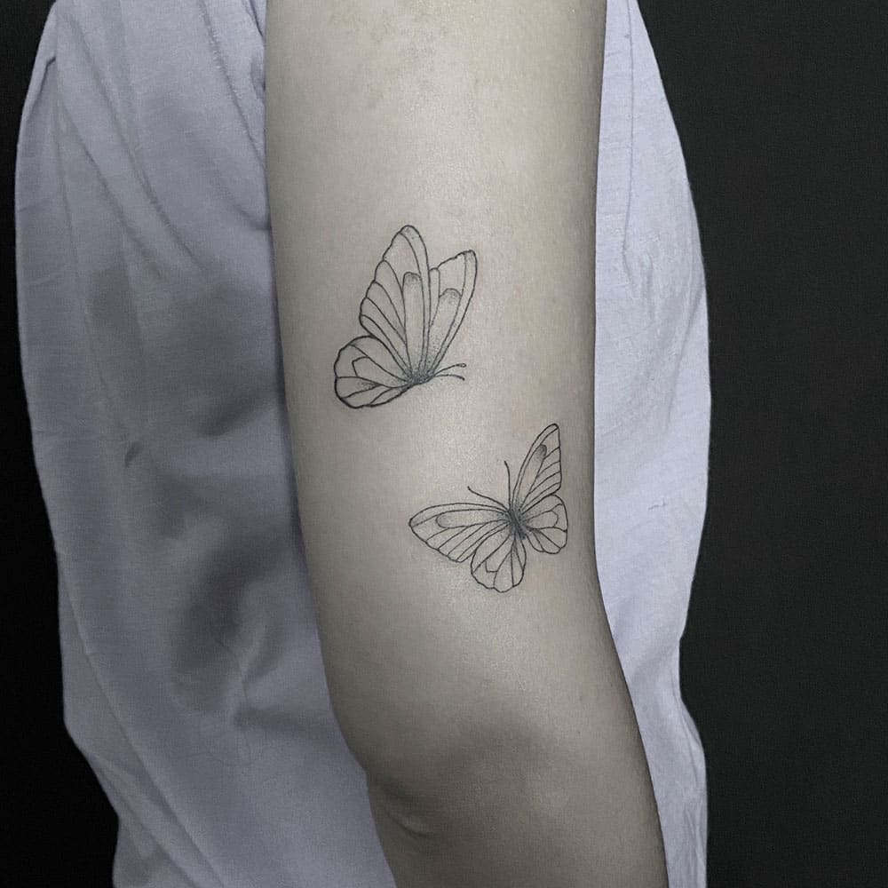 Lijnwerk minimalistische vlinder tattoo