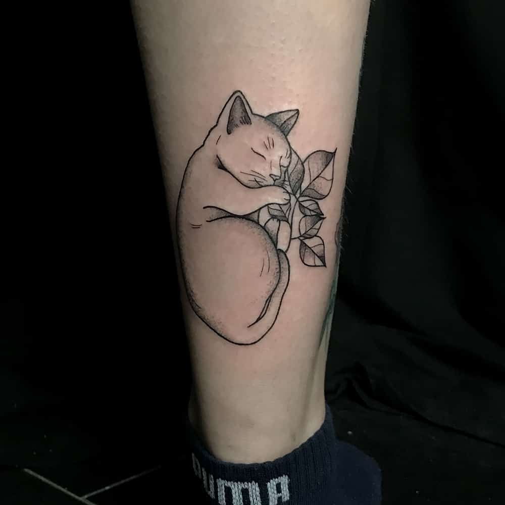 Slapend katje op bladeren tattoo