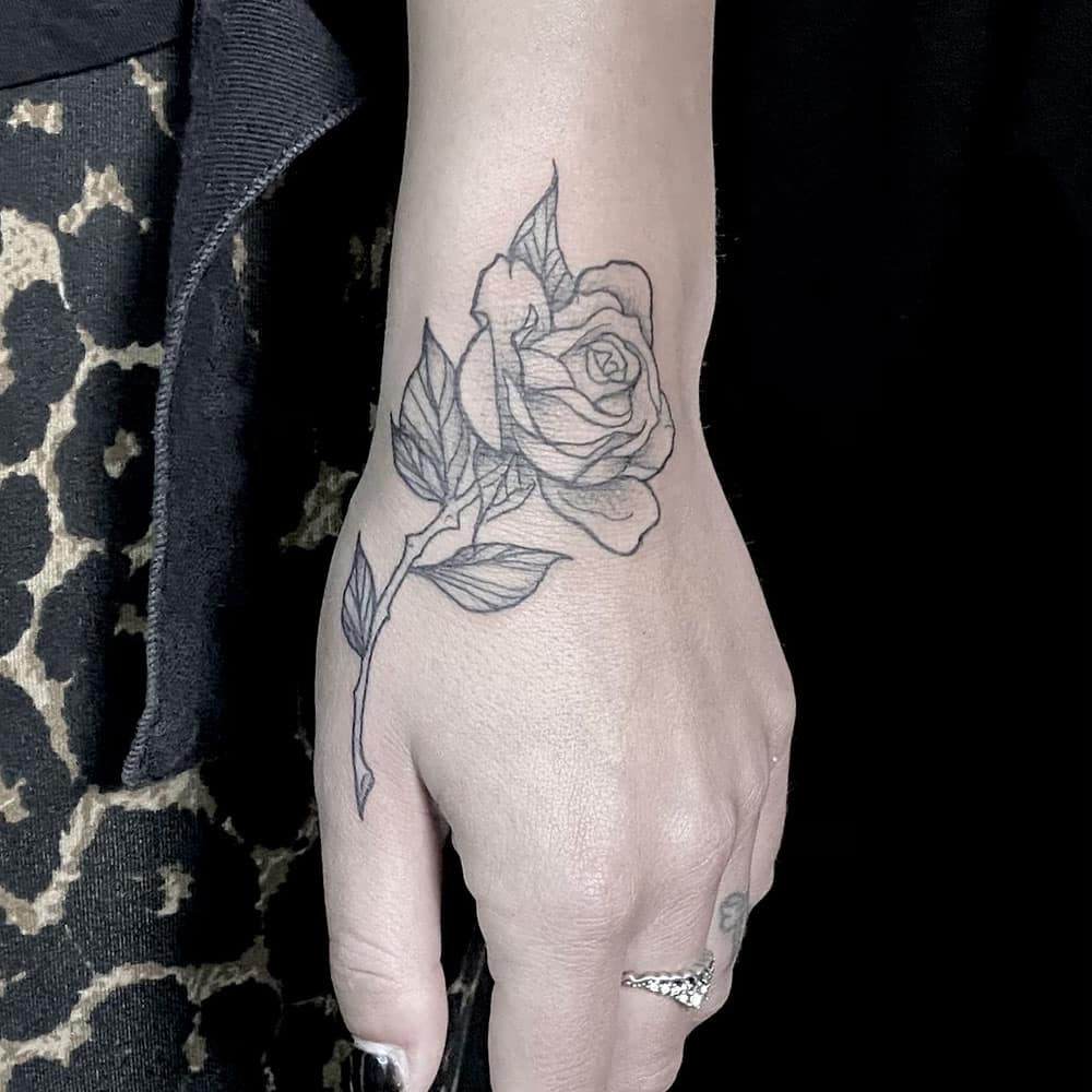 Roos op hand fijne lijntjes tattoo