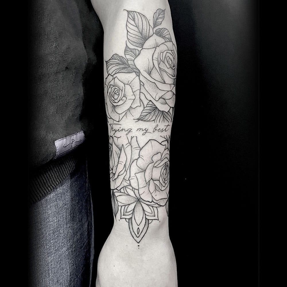 Sleeve met rozen en lettering tot de pols tattoo