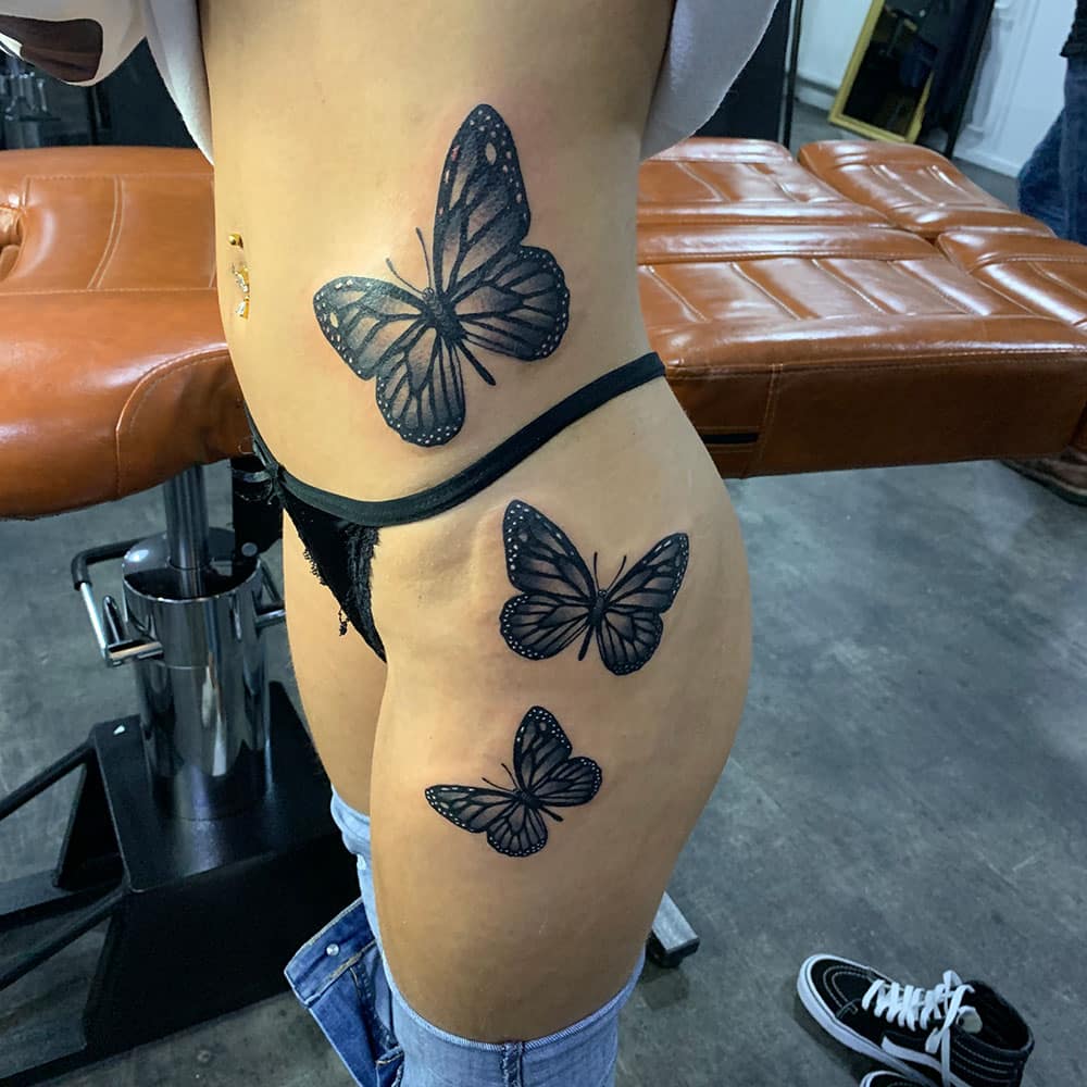 Drie vlinders blackwork tattoo zijkant lichaam en dijbeen