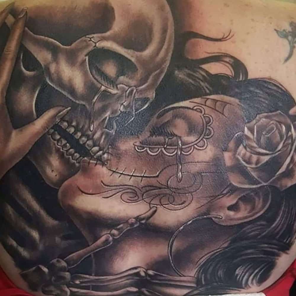 Chicano tattoo kussende schedel vrouw black and grey Declan
