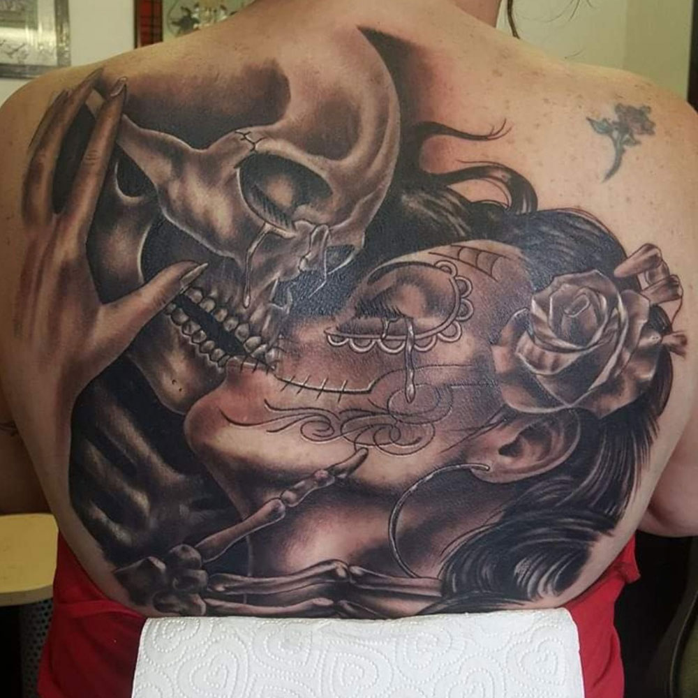 Chicano tattoo kussende schedel vrouw black and grey Declan