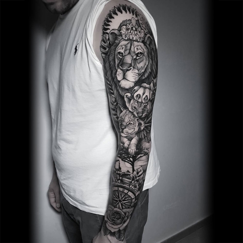 Blackwork leeuw welpjes kompas roos buitenkant sleeve tattoo Jona