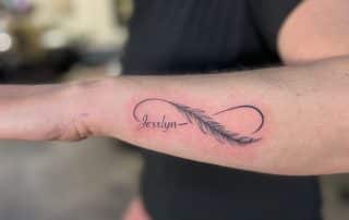 Infinity tattoo met veertje en naam